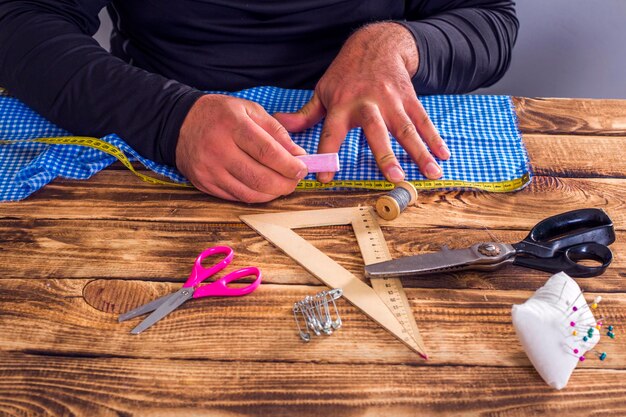 Giovane sarto che lavora con il tessuto in atelier