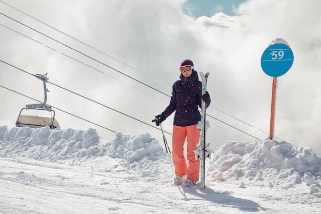 Giovane sciatrice in piedi sulla pista da sci seggiovia sullo sfondo Sochi Krasnaya Polyana Russia