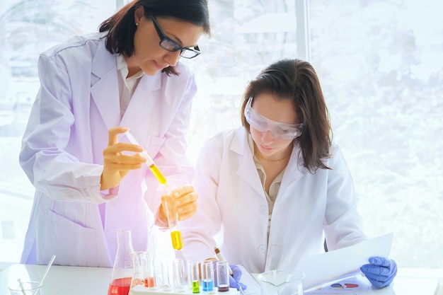 Giovane scienziato femminile che sta con l&#39;insegnante in laboratorio