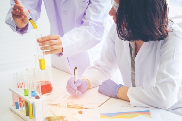 Giovane scienziato femminile che sta con l&#39;insegnante in laboratorio