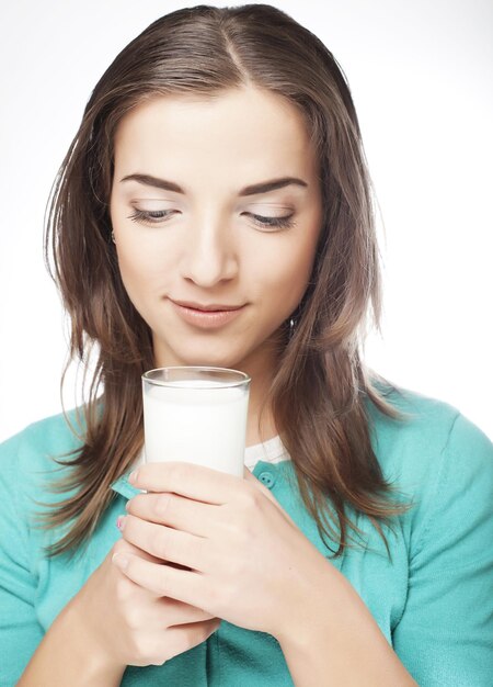 Giovane signora che mangia un bicchiere di latte