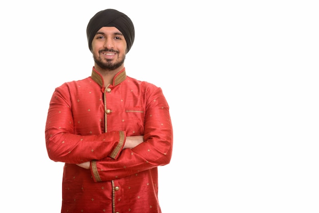 Giovane sikh indiano felice sorridente che indossa abiti tradizionali