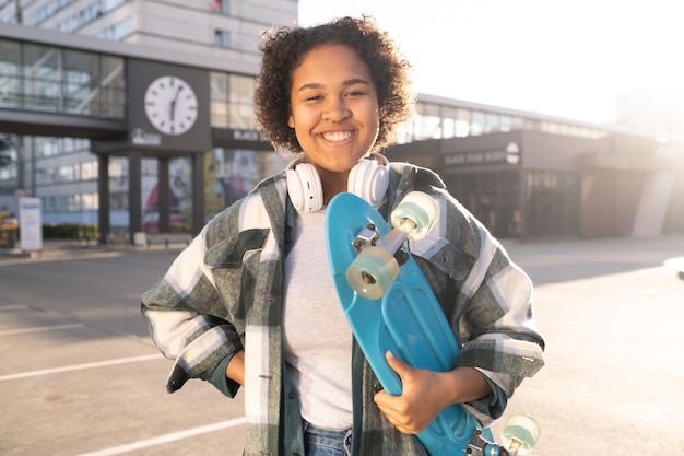 Giovane skateboarder attraente in abbigliamento casual che ti guarda