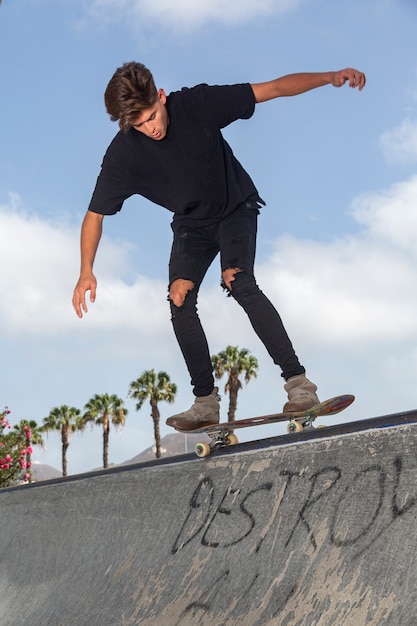 Giovane skateboarder che esegue i trucchi in un parco.