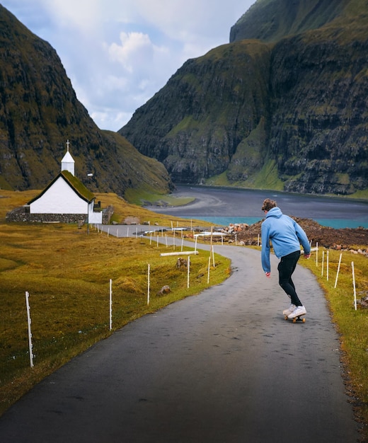 Giovane skater in sella a uno skateboard attraverso lo splendido scenario delle isole Faroe