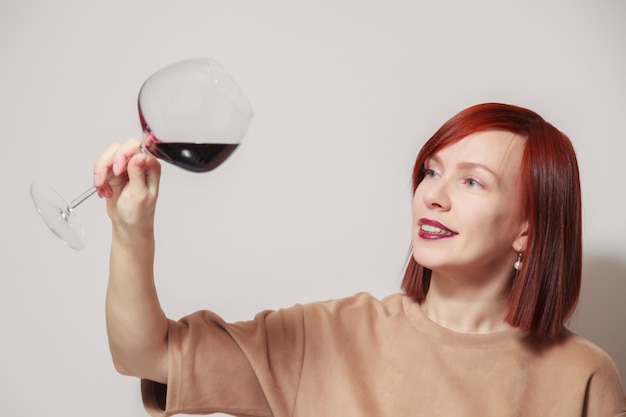 Giovane sommelier dai capelli rossi divertente della donna con il vetro di vino