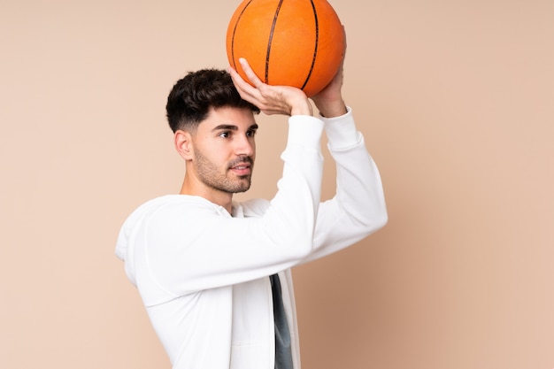 Giovane sopra isolato giocando a basket