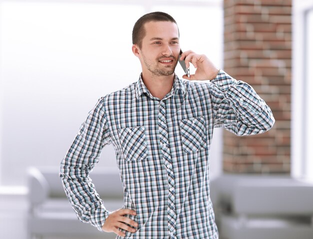 Giovane sorridente che parla sul telefono cellulare.