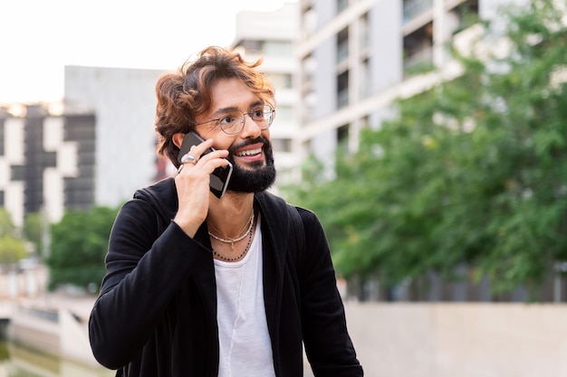 Giovane sorridente felice parlando sul telefono cellulare