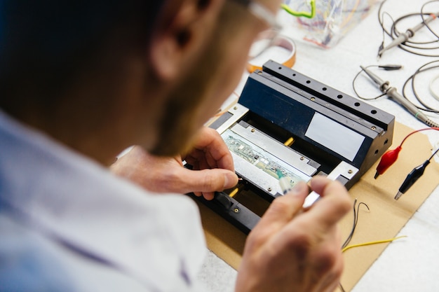 Giovane specialista di ricerca mani che lavorano in laboratorio elettronico