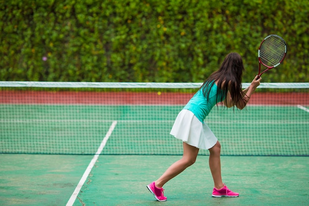 Giovane sportiva giocando a tennis in vacanza tropicale