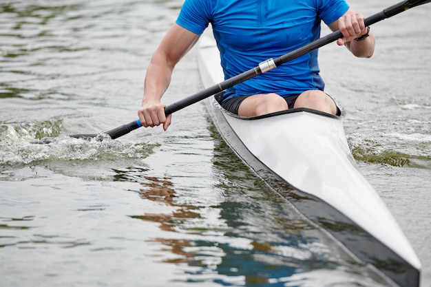 Giovane sportivo Pagaiando su una canoa