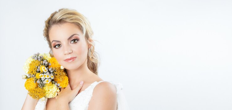 Giovane sposa caucasica bionda su sfondo bianco con versione panoramica del bouquet da sposa