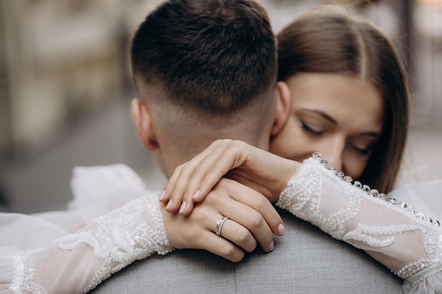 Giovane sposa con anello che abbraccia lo sposo