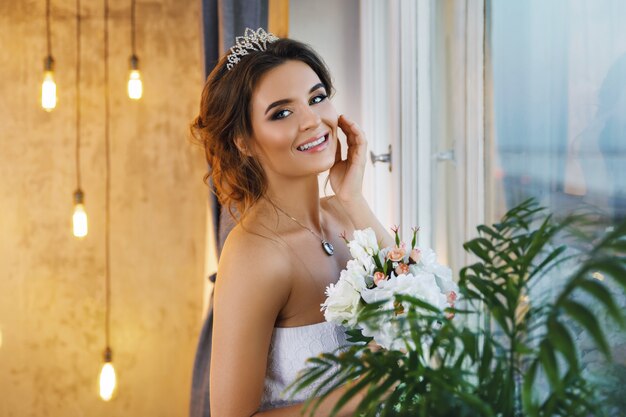 Giovane sposa felice che indossa un bel vestito lussureggiante