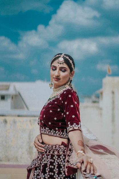 Giovane sposa indiana in lussuoso costume da sposa con trucco e gioielli pesanti