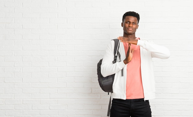 Giovane studente afro americano uomo facendo fermata gesto con la mano per fermare un atto