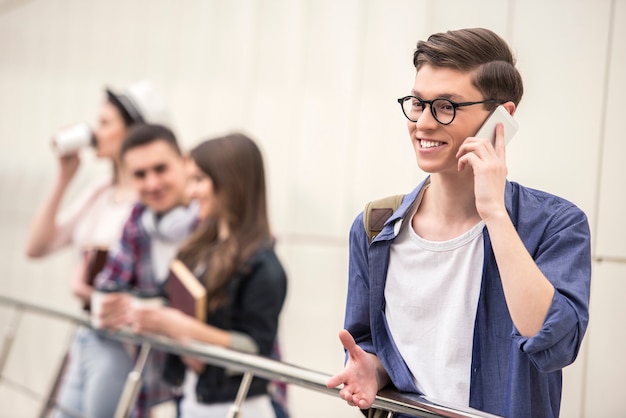 Giovane studente bello che parla sul telefono.