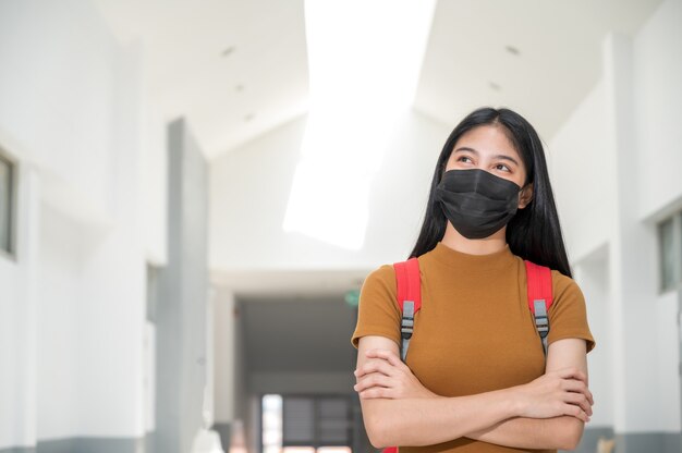 Giovane studente di college che indossa una maschera di panno nero, torna a scuola,