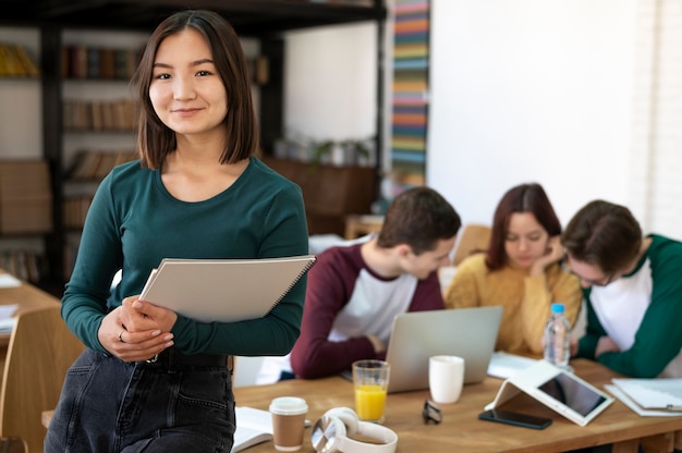 Giovane studente durante lo studio di gruppo in posa alla scrivania