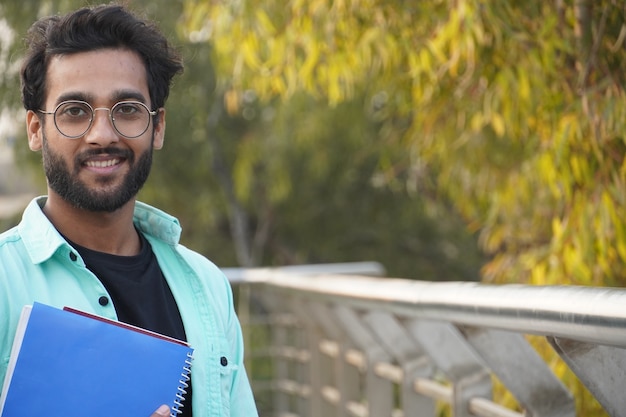 Giovane studente indiano con il primo piano del libro