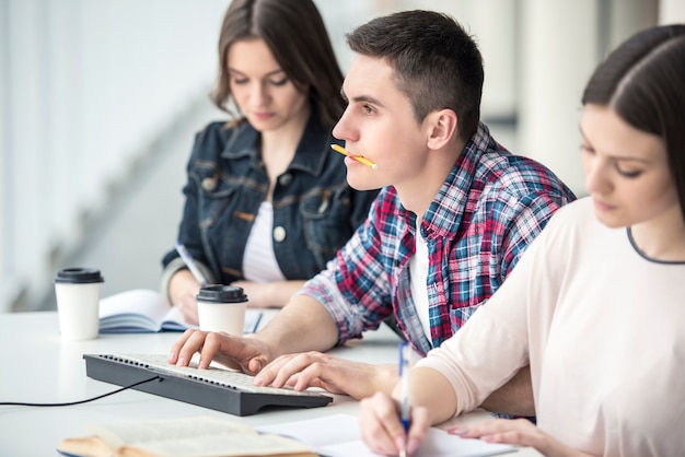 Giovane studente maschio che impara con il computer in istituto universitario.