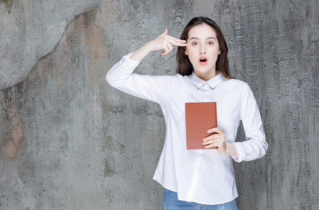 Giovane studente o insegnante con libro di letteratura in piedi. Foto di alta qualità