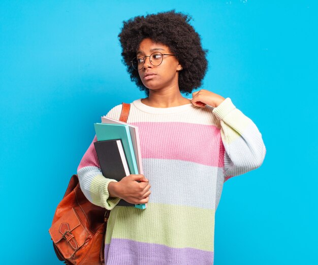 Giovane studentessa afro che si sente stressata, ansiosa, stanca e frustrata, tira il collo della camicia, sembra frustrata dal problema