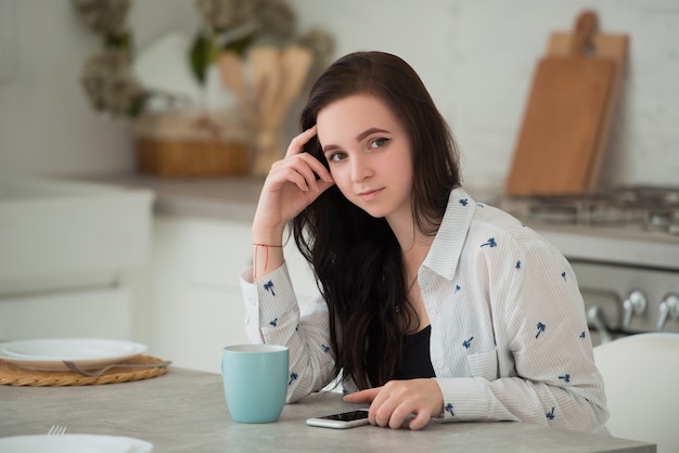 Giovane studentessa bruna con il cellulare