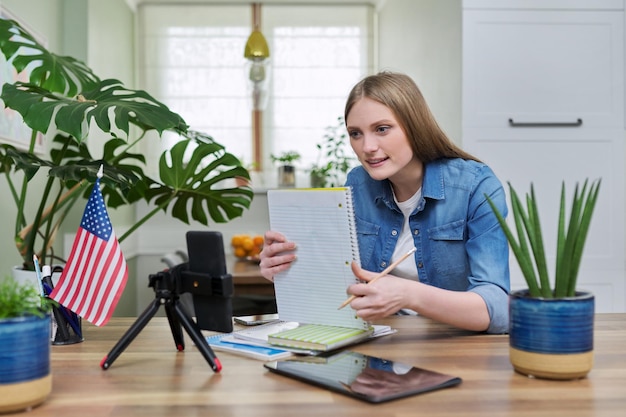 Giovane studentessa che studia a casa online in remoto Sfondo della bandiera degli Stati Uniti