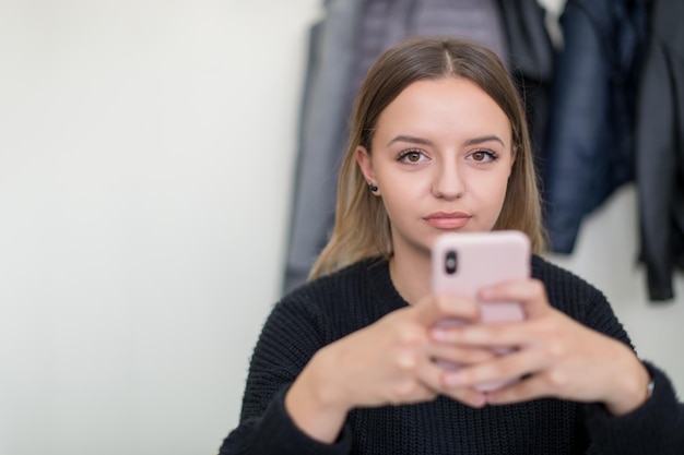 giovane studentessa che utilizza un telefono cellulare durante la pausa in classe