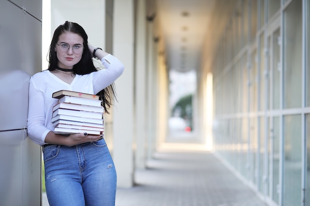 Giovane studentessa per strada con uno zaino e libri