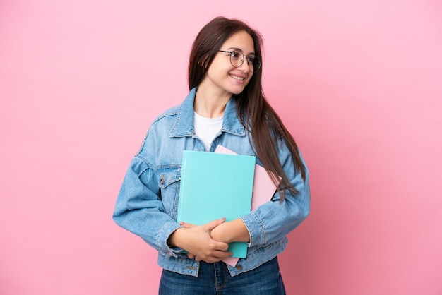 Giovane studentessa ucraina isolata su sfondo rosa guardando il lato