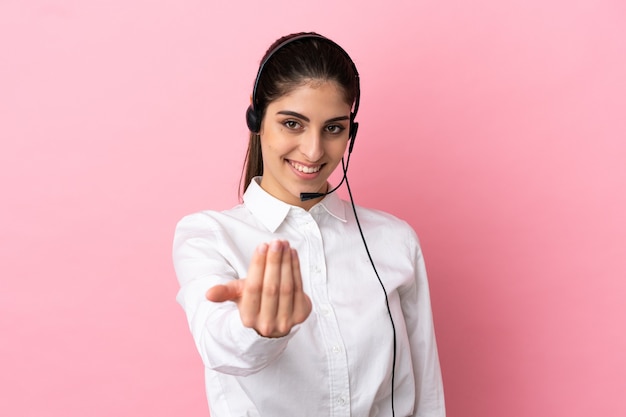 Giovane telemarketer su sfondo isolato che invita a venire con la mano. Felice che tu sia venuto