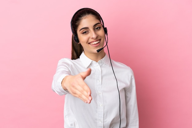 Giovane telemarketer su sfondo isolato che stringe la mano per aver chiuso un buon affare