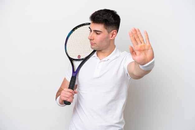 Giovane tennista uomo isolato su sfondo bianco che fa gesto di arresto e deluso