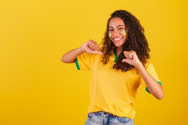 Giovane tifosa di calcio brasiliana nera che indica se stessa scegliendo se stessa