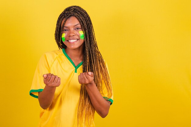 Giovane tifoso brasiliano di calcio della donna di colore che chiama con le vostre mani che invitano