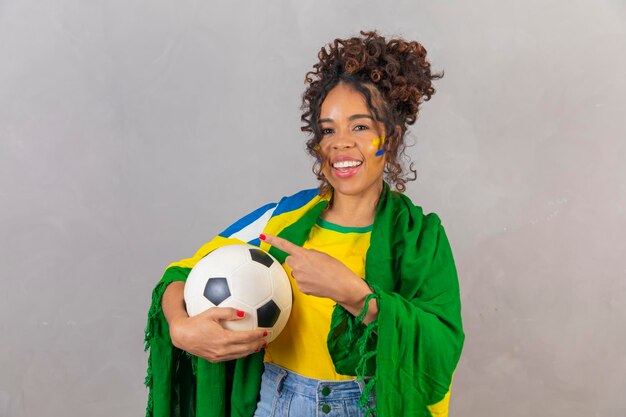 Giovane tifoso brasiliano nero che indica la foto pubblicitaria a sinistra