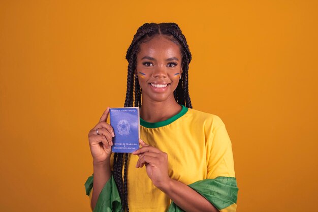 Giovane tifoso di calcio brasiliano nero donna in possesso di una carta brasiliana di lavoro e sicurezza sociale