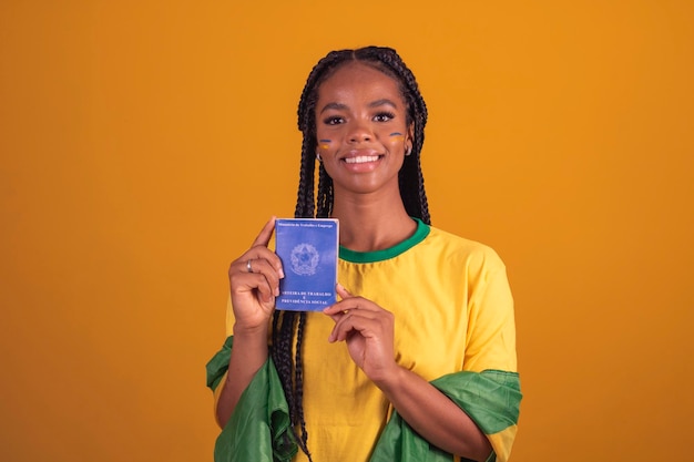 Giovane tifoso di calcio brasiliano nero donna in possesso di una carta brasiliana di lavoro e sicurezza sociale