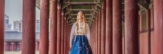 Giovane turista caucasica in abito nazionale coreano hanbok Concetto di viaggio in Corea Abbigliamento nazionale coreano Intrattenimento per turisti che provano abbigliamento nazionale coreano BANNER FORMATO LUNGO