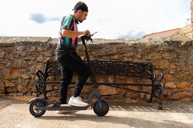 Giovane turista che guarda il cellulare per il percorso sul suo scooter elettrico