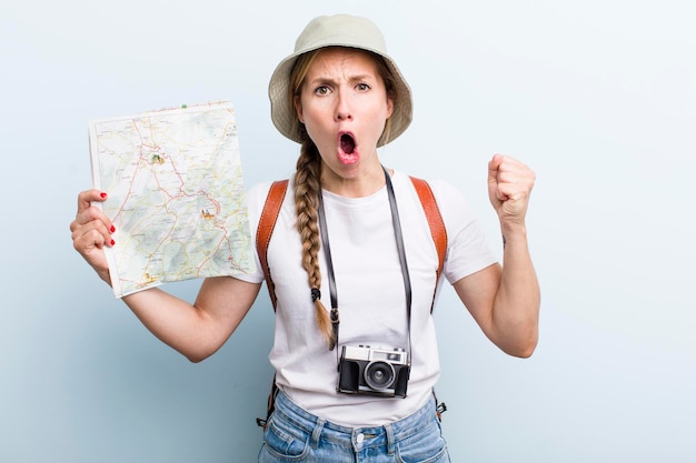 Giovane turista donna bionda adulta con un concetto di mappa