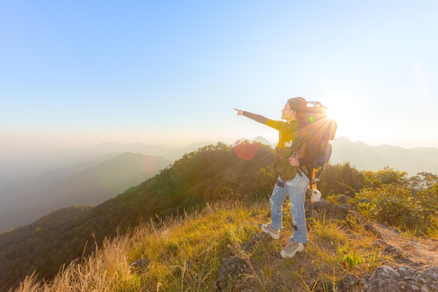 Giovane turista femminile che trasporta bagagli al tramonto