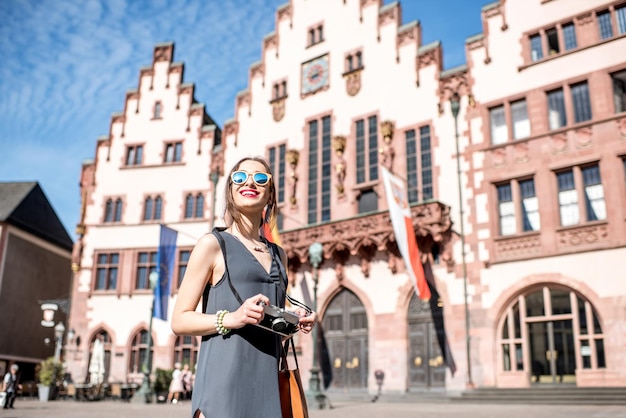 Giovane turista femminile con macchina fotografica che si diverte a visitare il centro storico della città di Francoforte