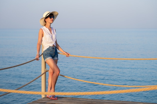 Giovane turista femminile in abiti casual che si gode una calda giornata di sole sulla riva del mare