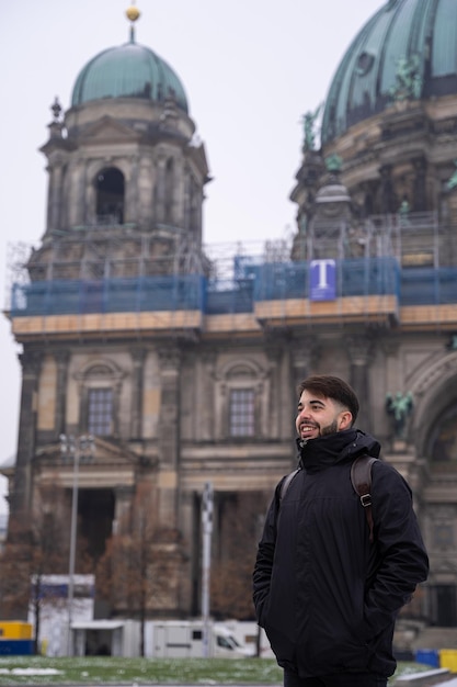 Giovane turista maschio con la barba e la cattedrale di Berlino sullo sfondo