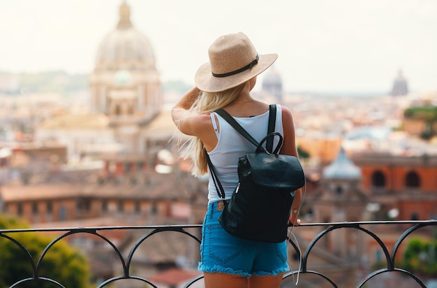 Giovane turista sorridente attraente della ragazza che esplora la nuova città in estate
