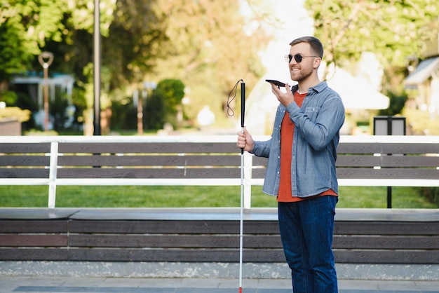 Giovane uomo accecato usando il telefono e inviando un messaggio vocale